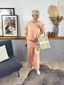 2-Teiler aus weicher Butter, Hose mit Gummibund und aufgesetzten Taschen, 7/8 Beinlänge mit hinter überkreuzter Naht. Wahlweise mit kurzem Ballon-Sweater oder längerer Variante mit überschnittener Schulter - vorne kurzer als hinten.